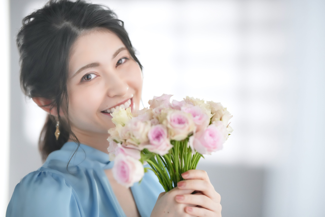 花束を持って微笑む女性