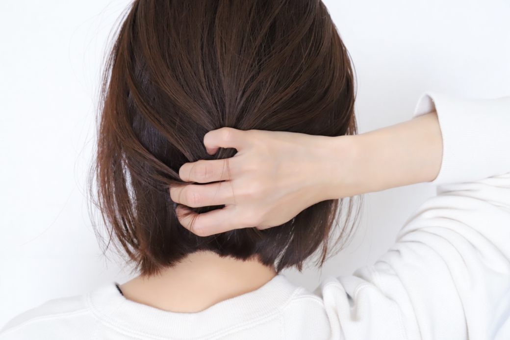 後ろ髪を触る女性