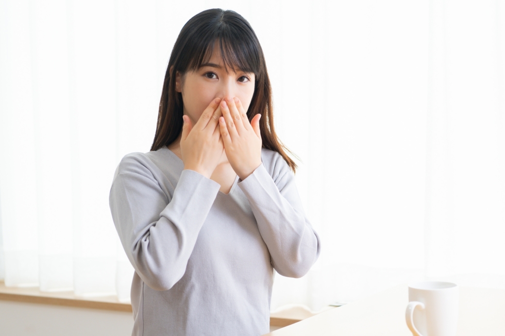 口を隠す若い女性