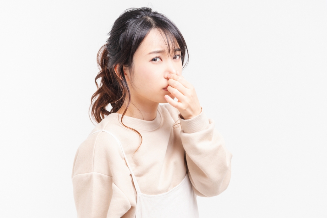 鼻をつまむ若い女性